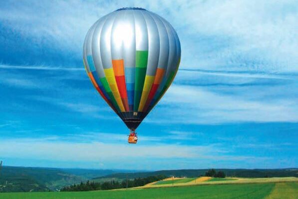 Ein bunter Heissluftballon in der Luft.